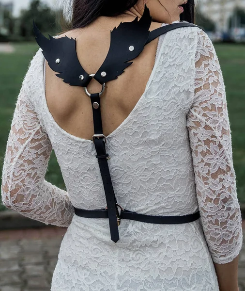 Kadın deri bir sandık takımı giymişti. Arkasında da Kuzgun kanadı şeklinde büyük delikli delikler vardı..