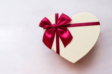 Beyaz arka planda kalp şeklinde bir hediye kutusu. Kutulu kalp. Kalp şeklinde izole edilmiş bir kutu. Yay şeklinde bir kalp şeklinde kutu.