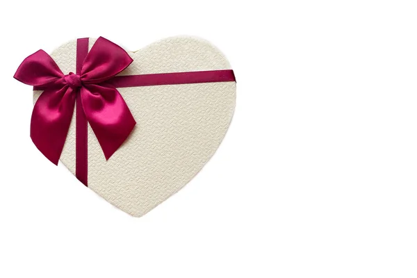 Beyaz arka planda kalp şeklinde bir hediye kutusu. Kutulu kalp. Kalp şeklinde izole edilmiş bir kutu. Yay şeklinde bir kalp şeklinde kutu.