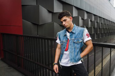 Adam binanın arka planında poz veriyor.