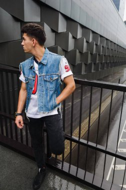 Adam binanın arka planında poz veriyor.