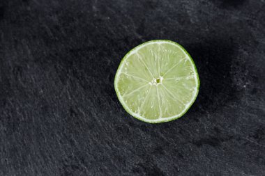 Limonlu arka plan. Taş zemindeki limon dilimleri. Taş bir masada. Metin için boş alan. Yukarıdan görünüşü