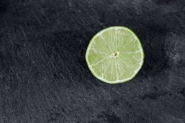 Limonlu arka plan. Taş zemindeki limon dilimleri. Taş bir masada. Metin için boş alan. Yukarıdan görünüşü