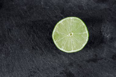 Limonlu arka plan. Taş zemindeki limon dilimleri. Taş bir masada. Metin için boş alan. Yukarıdan görünüşü