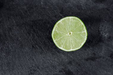 Limonlu arka plan. Taş zemindeki limon dilimleri. Taş bir masada. Metin için boş alan. Yukarıdan görünüşü