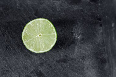 Limonlu arka plan. Taş zemindeki limon dilimleri. Taş bir masada. Metin için boş alan. Yukarıdan görünüşü