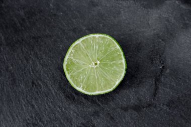 Limonlu arka plan. Taş zemindeki limon dilimleri. Taş bir masada. Metin için boş alan. Yukarıdan görünüşü