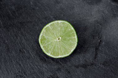 Limonlu arka plan. Taş zemindeki limon dilimleri. Taş bir masada. Metin için boş alan. Yukarıdan görünüşü