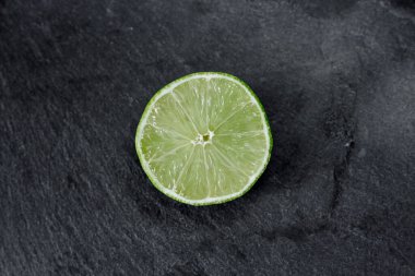 Limonlu arka plan. Taş zemindeki limon dilimleri. Taş bir masada. Metin için boş alan. Yukarıdan görünüşü