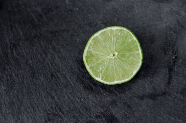 Limonlu arka plan. Taş zemindeki limon dilimleri. Taş bir masada. Metin için boş alan. Yukarıdan görünüşü