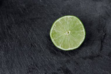 Limonlu arka plan. Taş zemindeki limon dilimleri. Taş bir masada. Metin için boş alan. Yukarıdan görünüşü