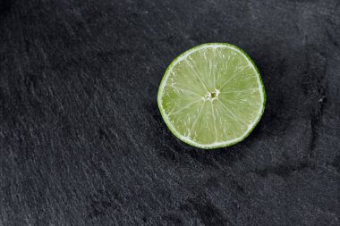 Limonlu arka plan. Taş zemindeki limon dilimleri. Taş bir masada. Metin için boş alan. Yukarıdan görünüşü