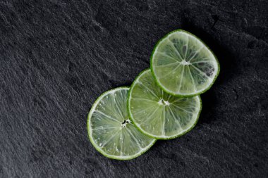 Limonlu arka plan. Taş zemindeki limon dilimleri. Taş bir masada. Metin için boş alan. Yukarıdan görünüşü