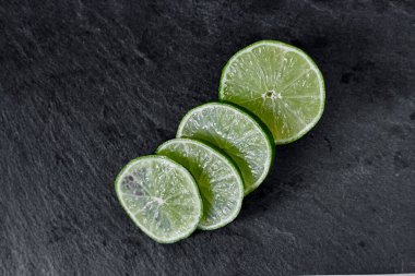 Limonlu arka plan. Taş zemindeki limon dilimleri. Taş bir masada. Metin için boş alan. Yukarıdan görünüşü