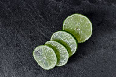 Limonlu arka plan. Taş zemindeki limon dilimleri. Taş bir masada. Metin için boş alan. Yukarıdan görünüşü