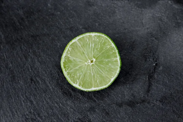 Lime background. The slices of lime on a stone base. On a stone table. Free space for text . The view from the top