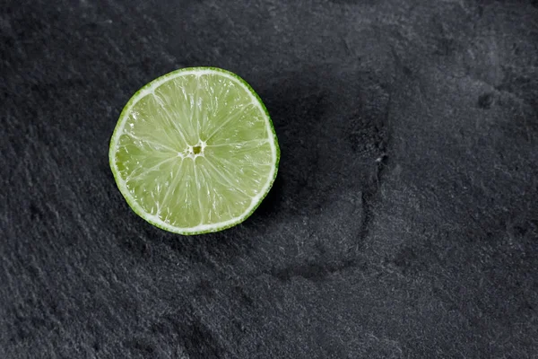 Lime background. The slices of lime on a stone base. On a stone table. Free space for text . The view from the top