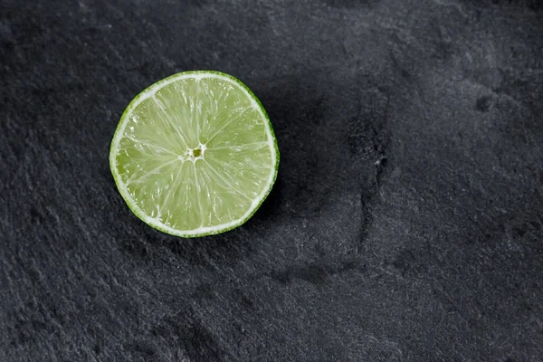 Lime background. The slices of lime on a stone base. On a stone table. Free space for text . The view from the top