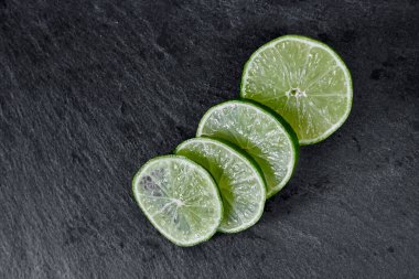 Limonlu arka plan. Taş zemindeki limon dilimleri. Taş bir masada. Metin için boş alan. Yukarıdan görünüşü