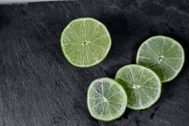 Limonlu arka plan. Taş zemindeki limon dilimleri. Taş bir masada. Metin için boş alan. Yukarıdan görünüşü