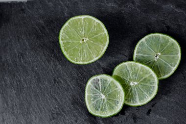 Limonlu arka plan. Taş zemindeki limon dilimleri. Taş bir masada. Metin için boş alan. Yukarıdan görünüşü