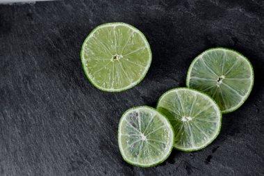 Limonlu arka plan. Taş zemindeki limon dilimleri. Taş bir masada. Metin için boş alan. Yukarıdan görünüşü