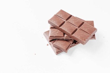 Beyaz arka planda izole edilmiş sütlü çikolata parçaları, beyaz arkaplanda izole edilmiş çikolatayı kapat