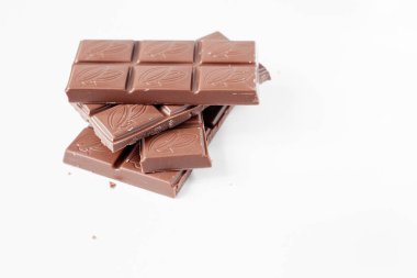 Beyaz arka planda izole edilmiş sütlü çikolata parçaları, beyaz arkaplanda izole edilmiş çikolatayı kapat