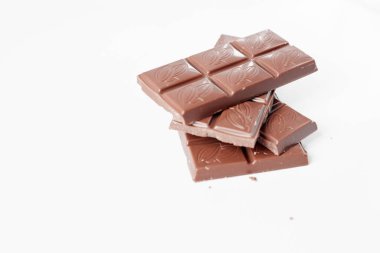 Beyaz arka planda izole edilmiş sütlü çikolata parçaları, beyaz arkaplanda izole edilmiş çikolatayı kapat