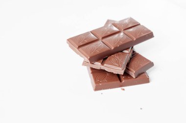 Beyaz arka planda izole edilmiş sütlü çikolata parçaları, beyaz arkaplanda izole edilmiş çikolatayı kapat