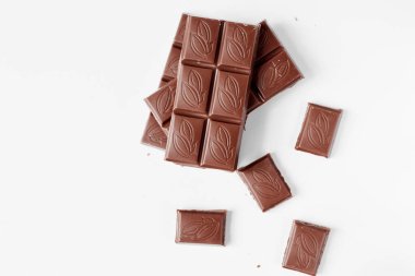 Beyaz arka planda izole edilmiş sütlü çikolata parçaları, beyaz arkaplanda izole edilmiş çikolatayı kapat