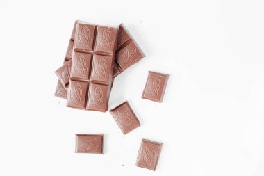 Beyaz arka planda izole edilmiş sütlü çikolata parçaları, beyaz arkaplanda izole edilmiş çikolatayı kapat