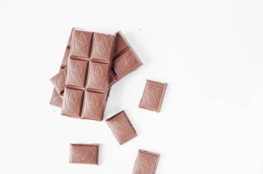 Beyaz arka planda izole edilmiş sütlü çikolata parçaları, beyaz arkaplanda izole edilmiş çikolatayı kapat