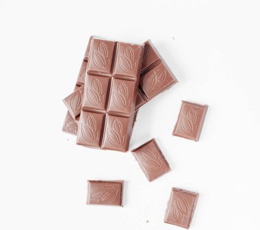 Beyaz arka planda izole edilmiş sütlü çikolata parçaları, beyaz arkaplanda izole edilmiş çikolatayı kapat