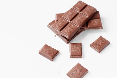 Beyaz arka planda izole edilmiş sütlü çikolata parçaları, beyaz arkaplanda izole edilmiş çikolatayı kapat