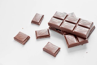 Beyaz arka planda izole edilmiş sütlü çikolata parçaları, beyaz arkaplanda izole edilmiş çikolatayı kapat