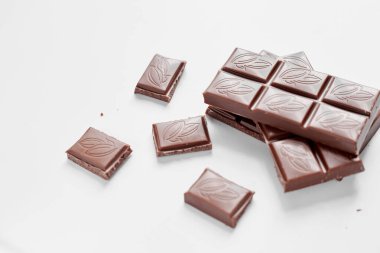 Beyaz arka planda izole edilmiş sütlü çikolata parçaları, beyaz arkaplanda izole edilmiş çikolatayı kapat