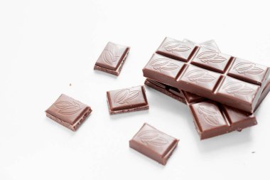 Beyaz arka planda izole edilmiş sütlü çikolata parçaları, beyaz arkaplanda izole edilmiş çikolatayı kapat