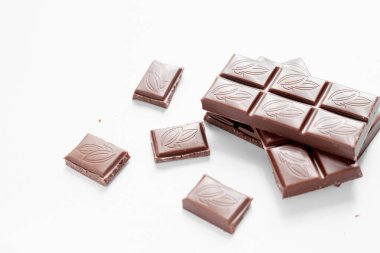 Beyaz arka planda izole edilmiş sütlü çikolata parçaları, beyaz arkaplanda izole edilmiş çikolatayı kapat