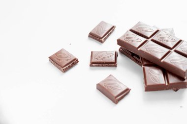 Beyaz arka planda izole edilmiş sütlü çikolata parçaları, beyaz arkaplanda izole edilmiş çikolatayı kapat