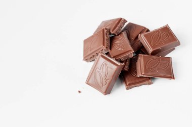 Beyaz arka planda izole edilmiş sütlü çikolata parçaları, beyaz arkaplanda izole edilmiş çikolatayı kapat