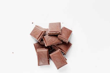 Beyaz arka planda izole edilmiş sütlü çikolata parçaları, beyaz arkaplanda izole edilmiş çikolatayı kapat