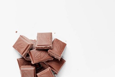 Beyaz arka planda izole edilmiş sütlü çikolata parçaları, beyaz arkaplanda izole edilmiş çikolatayı kapat