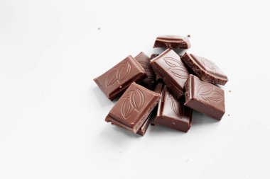 Beyaz arka planda izole edilmiş sütlü çikolata parçaları, beyaz arkaplanda izole edilmiş çikolatayı kapat