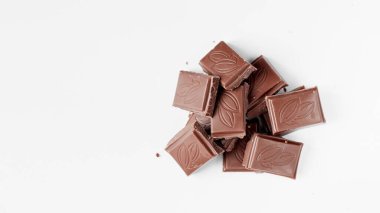 Beyaz arka planda izole edilmiş sütlü çikolata parçaları, beyaz arkaplanda izole edilmiş çikolatayı kapat