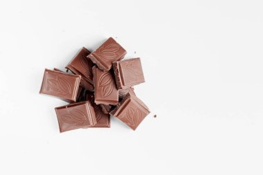 Beyaz arka planda izole edilmiş sütlü çikolata parçaları, beyaz arkaplanda izole edilmiş çikolatayı kapat