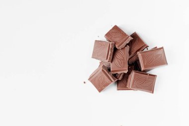 Beyaz arka planda izole edilmiş sütlü çikolata parçaları, beyaz arkaplanda izole edilmiş çikolatayı kapat