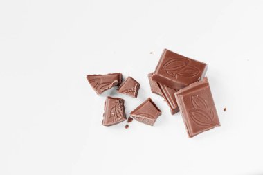 Beyaz arka planda izole edilmiş sütlü çikolata parçaları, beyaz arkaplanda izole edilmiş çikolatayı kapat