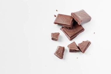 Beyaz arka planda izole edilmiş sütlü çikolata parçaları, beyaz arkaplanda izole edilmiş çikolatayı kapat