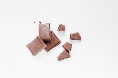 Beyaz arka planda izole edilmiş sütlü çikolata parçaları, beyaz arkaplanda izole edilmiş çikolatayı kapat